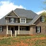 Feels Like Home from the Moment You Walk In 3 Classic two-story brick house with gable roof and front lawn in suburban setting.
